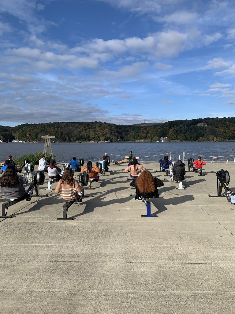 Students learning how to practice rowing technique on an "erg" with our beautiful Hudson River in the background.